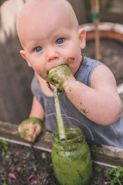 Baby drinking a natural green smoothie